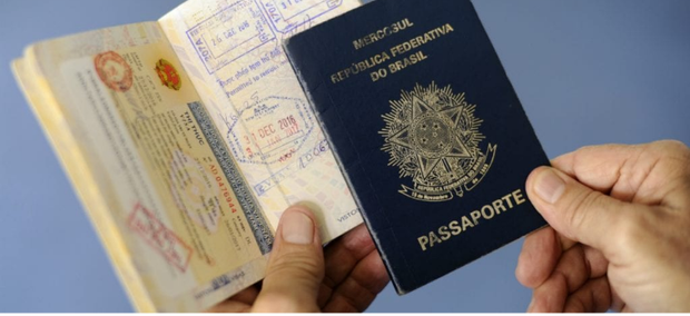 Passaporte brasileiro sendo exibido com visto em destaque.